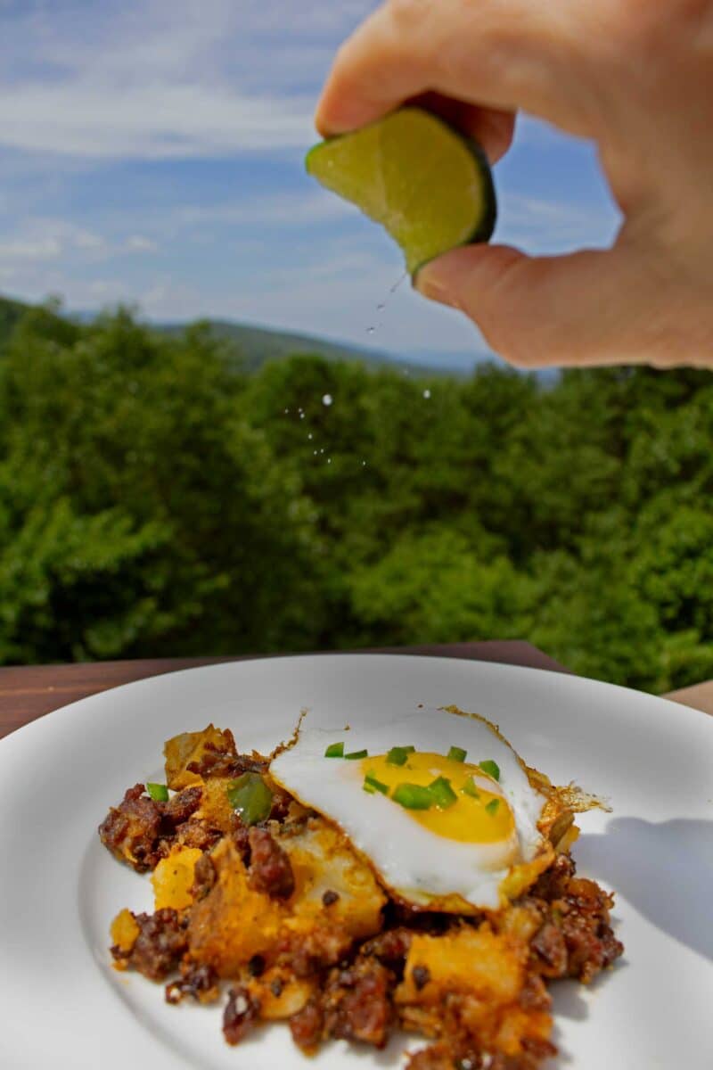 squeezing lime over chorizo breakfast hash