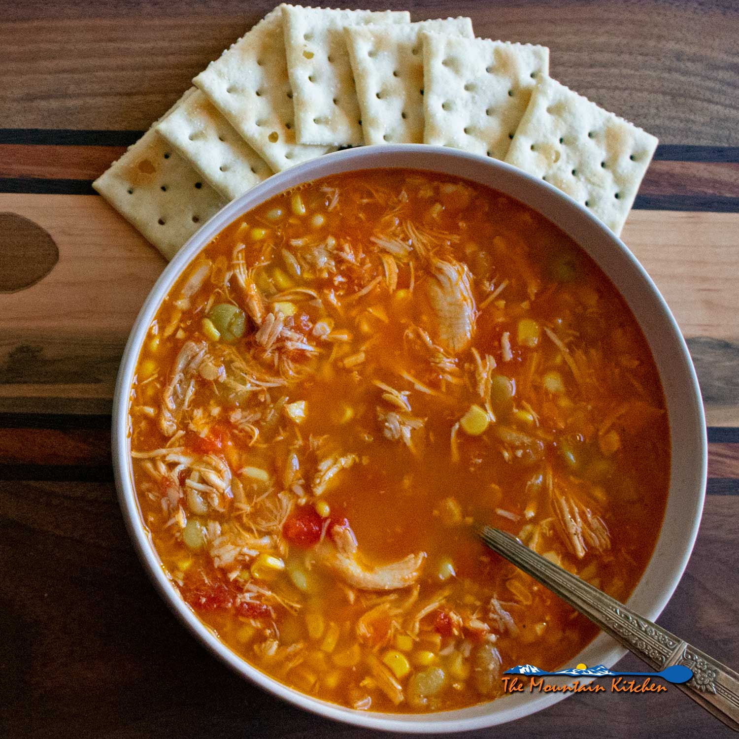 bowl of chicken vegetable soup in bowl with crackers