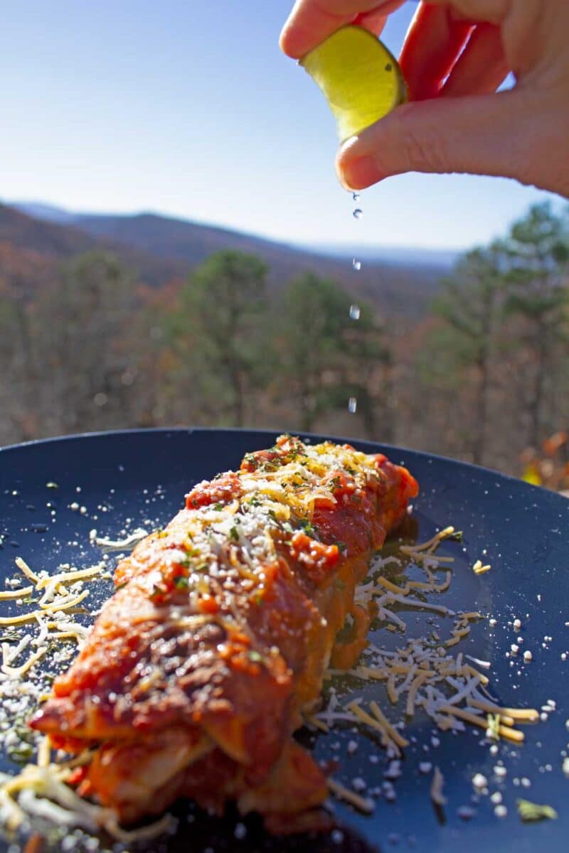 hand squeezing lime juice onto enchilada