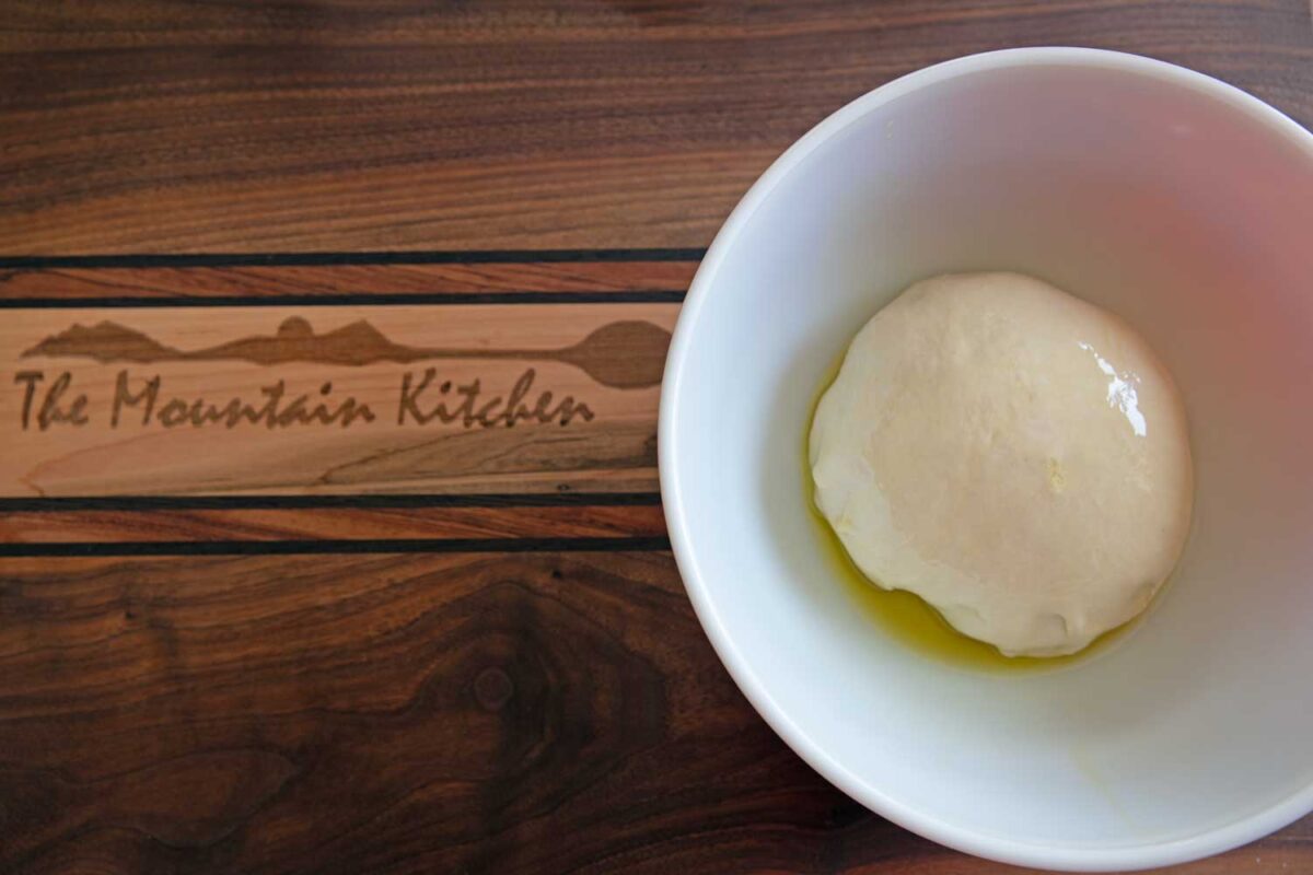 ball of bread dough in greased bowl