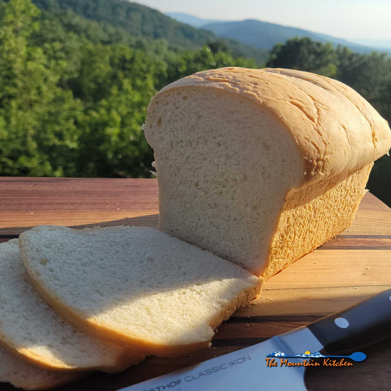 loaf of sliced sandwich bread on cutting board with knife