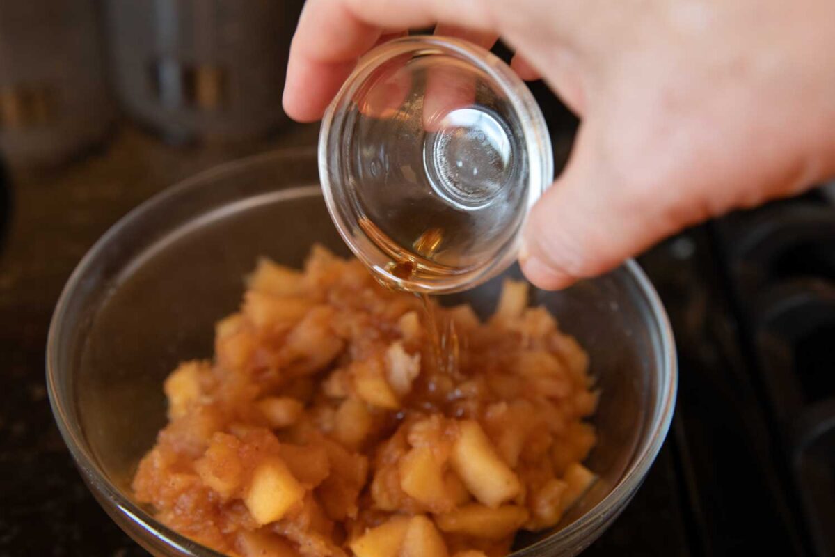 pouring vanilla into apple filling