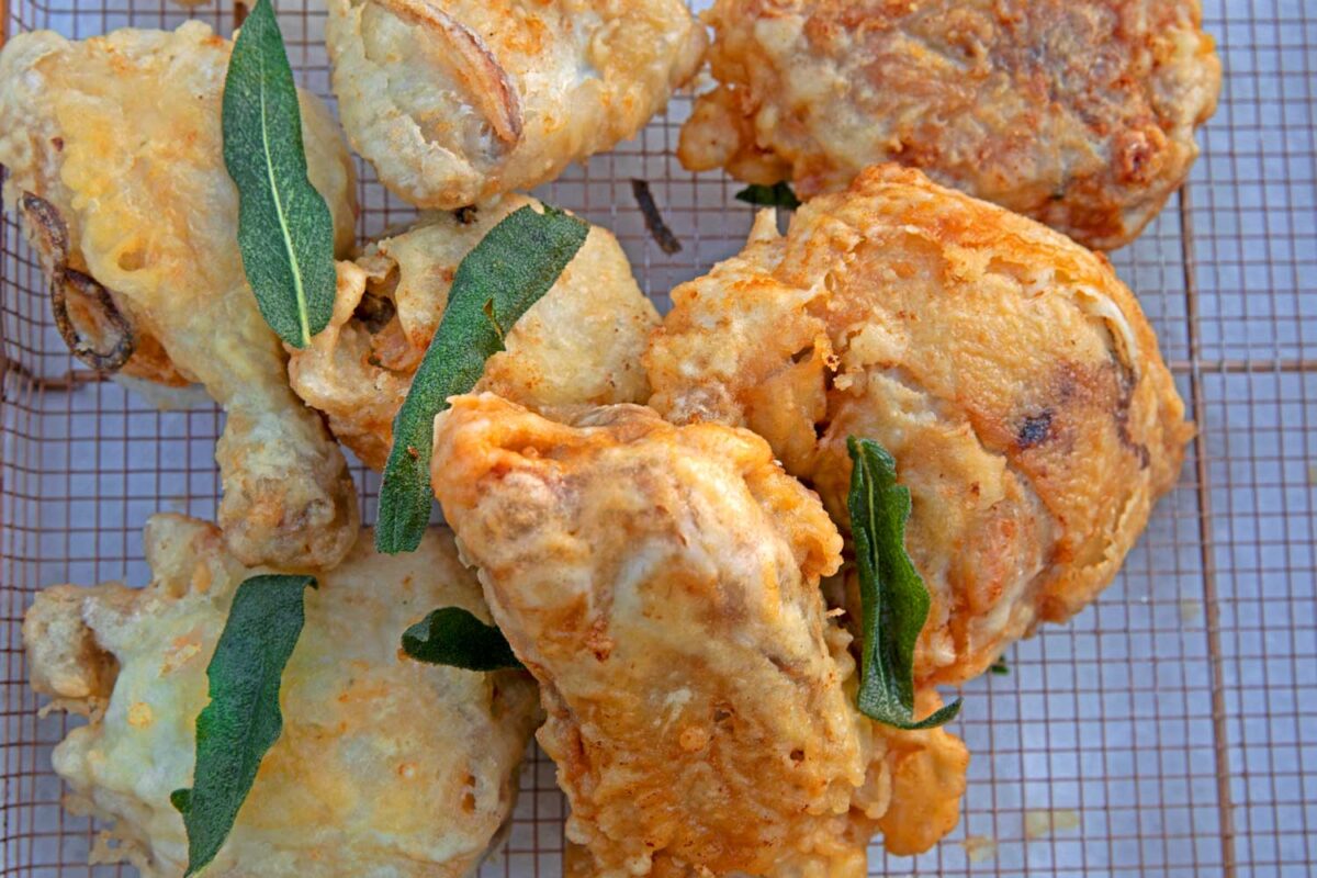 crispy fried chicken pieces draining on a wire rack