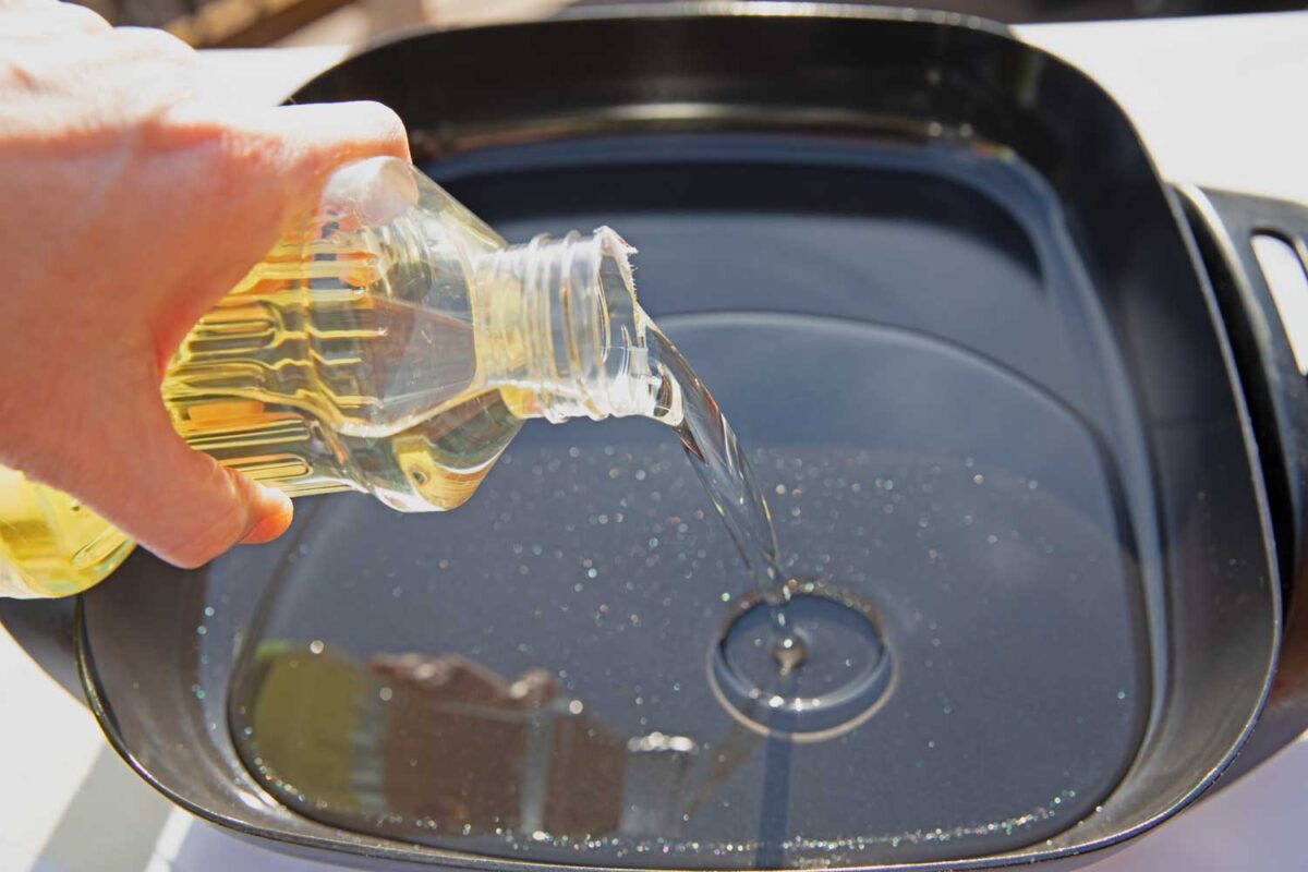 pouring oil into the electric frying pan